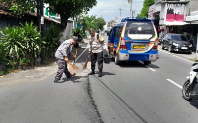 Cegah Kecelakaan Lalu Lintas, Bhabinkamtibmas Jagalan Timbun Tumpahan Oli di Jalan dengan Pasir