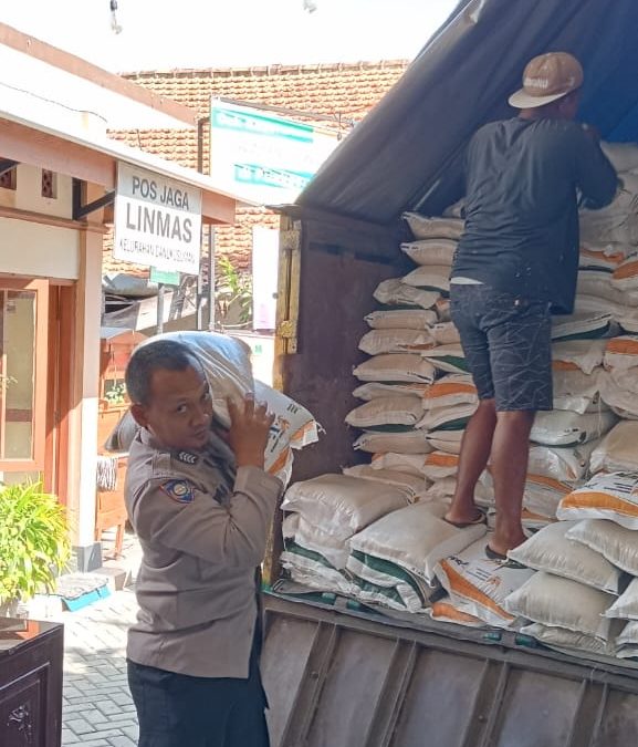 Bhabinkamtibmas Danukusuman Bantu Bongkar Muat Beras Bantuan Pangan untuk Warga
