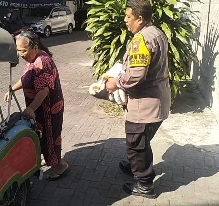 Bhabinkamtibmas Pasar Kliwon Bantu Warga Angkat Beras Bantuan Pemerintah