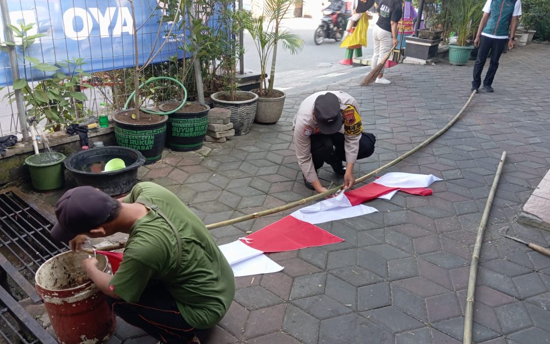 Sambut HUT RI ke-80, Bhabinkamtibmas Gandekan Bersama Linmas Gelar Kerja Bakti dan Pasang Umbul-Umbul